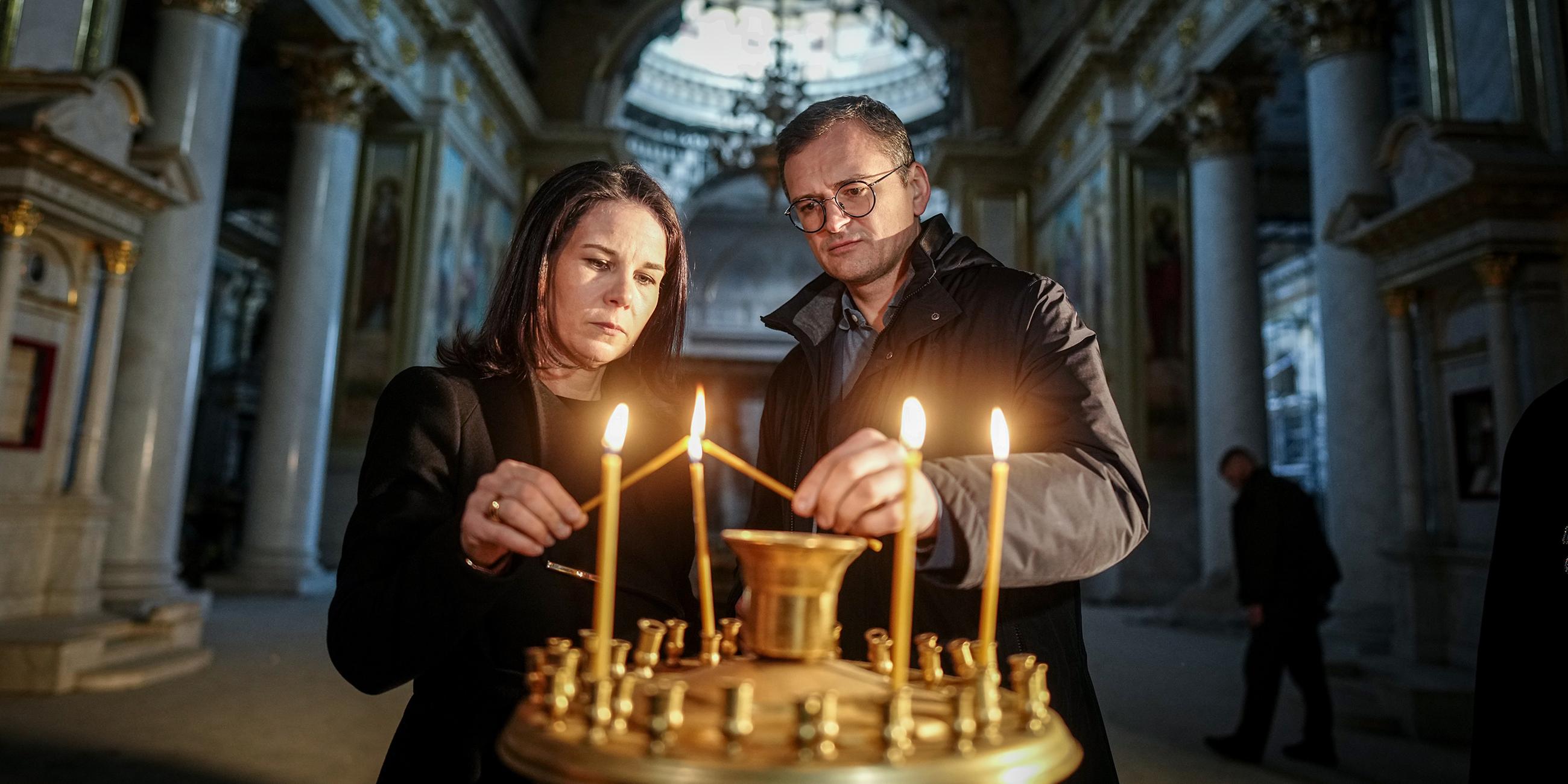 Annalena Baerbock und Dmytro Kuleba entzünden Kerzen in der Kathedrale von Odessa