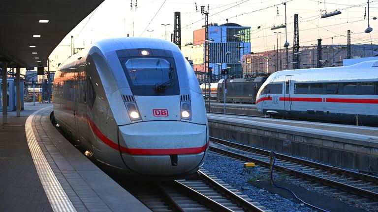 Ein ICE-Schnellzug bei der Einfahrt in das weitlaeufige Gleisvorfeld des Muenchner Hauptbahnhofs im Abendlicht.
