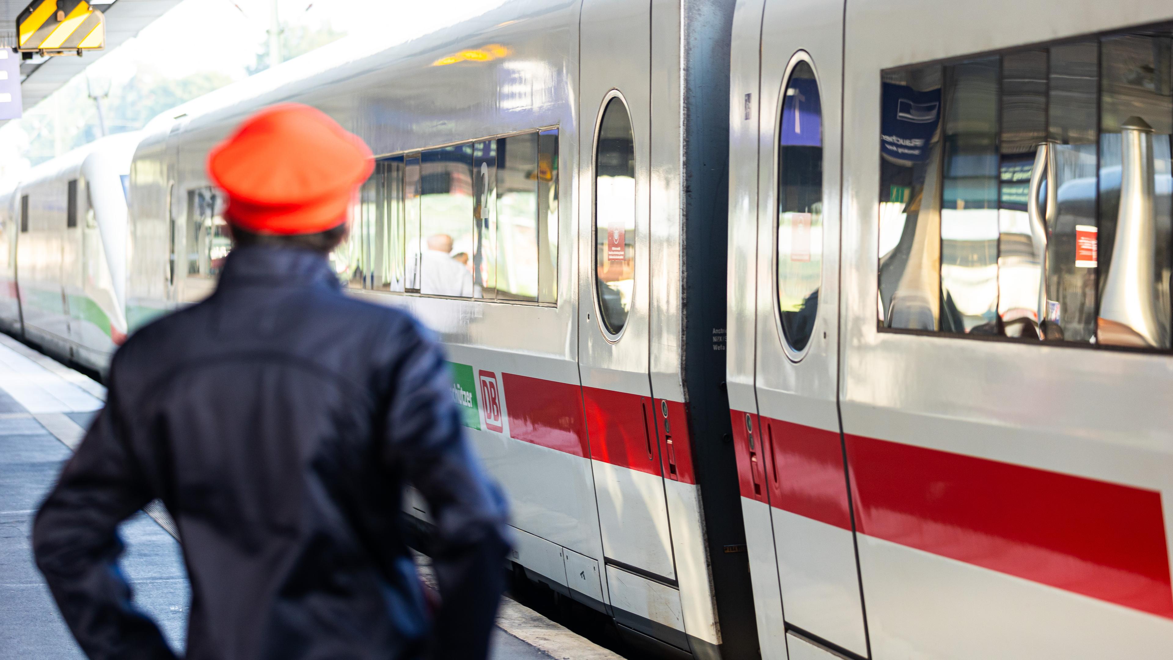 Ein Mitarbeiter der Bahn steht neben einem ICE-Zug an einem Gleis im Hauptbahnhof Hannover.