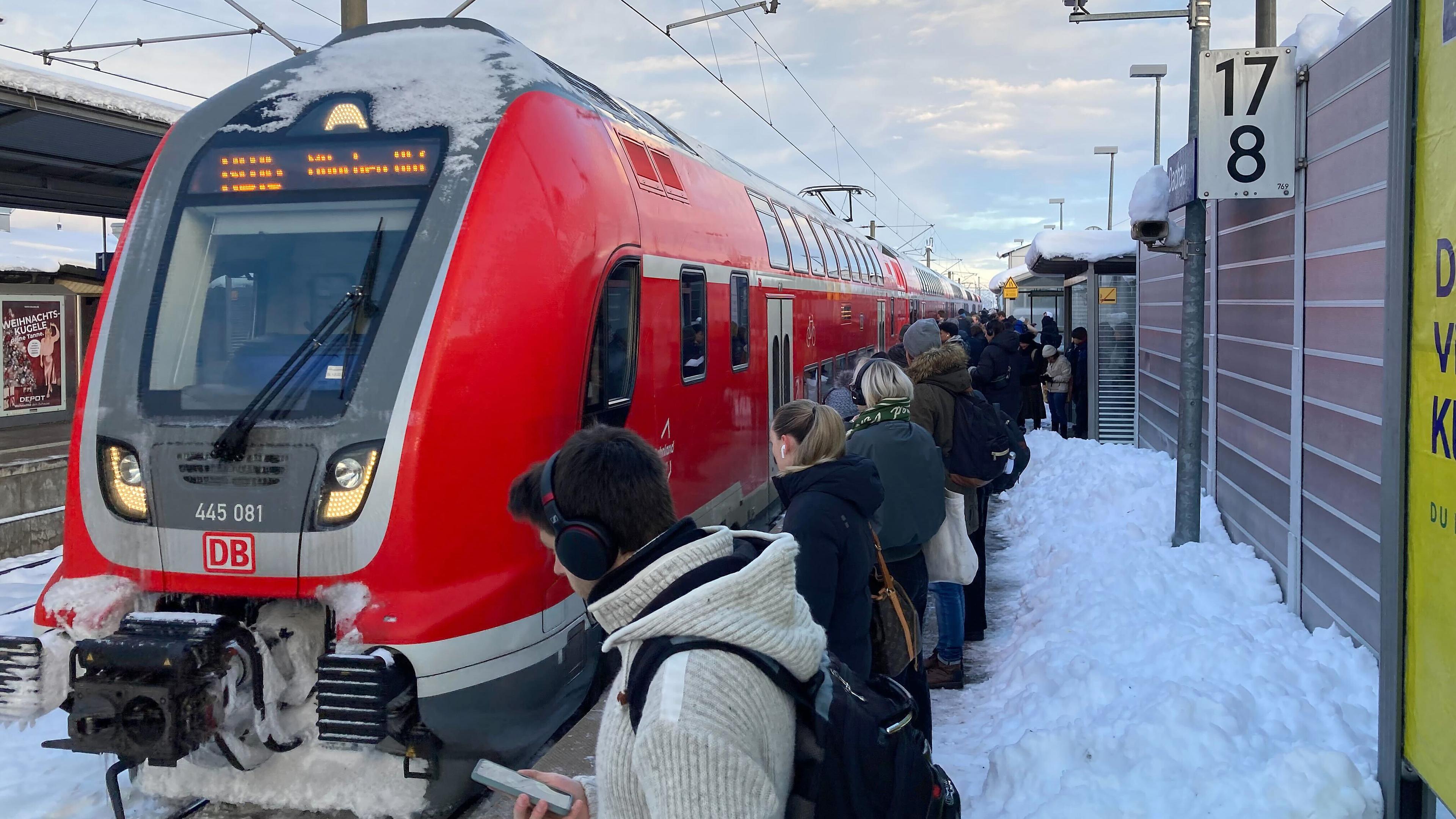 Zahlreiche Bahnpassagiere warten in Dachau auf einen der wenigen Züge, die bei den aktuellen Wetterbedingungen in Richtung München fahren, aufgenommen am 05.12.2023