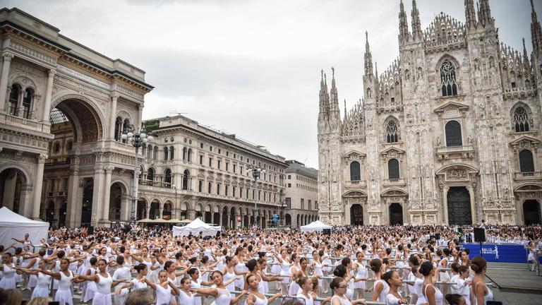 Italian ballet dancer Roberto Bolle (unseen) dances with 2000 students of dance schools at Piazza Duomo on the occasion of the OnDance dance festival (Ballo in Bianco), in Milan, Italy