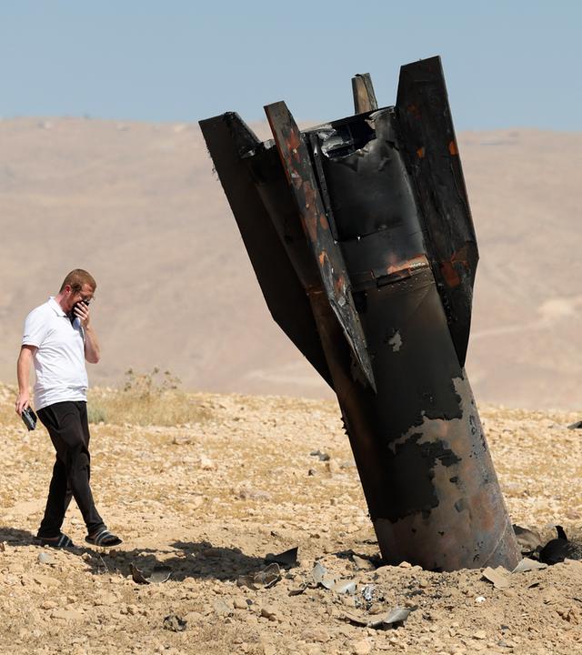 Ein Mann betrachtet die Überreste einer iranischen ballistischen Rakete, die am 08.06.2026 auf einem offenen Feld neben der Siedlung Mevo’ot Yericho im Westjordanland im Jordantal eingeschlagen ist. 