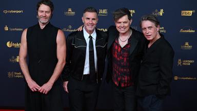 Die Band "Take That" mit Gary Barlow (2.v.l.), Howard Donald (l) und Mark Owen (r) mit Sänger Michael Patrick Kelly auf dem roten Teppich der Verleihung des Medienpreises Goldene Henne am 04.09.2026 in Leipzig. 