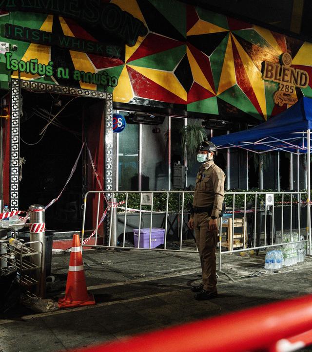 Ein Polizist steht vor einer ausgebrannten Bar im Bangkoker Stadtviertel Lad Prao.