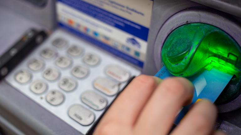 Berlin: Eine Bankkundin steckt ihre Girokarte in einen Geldautomaten.