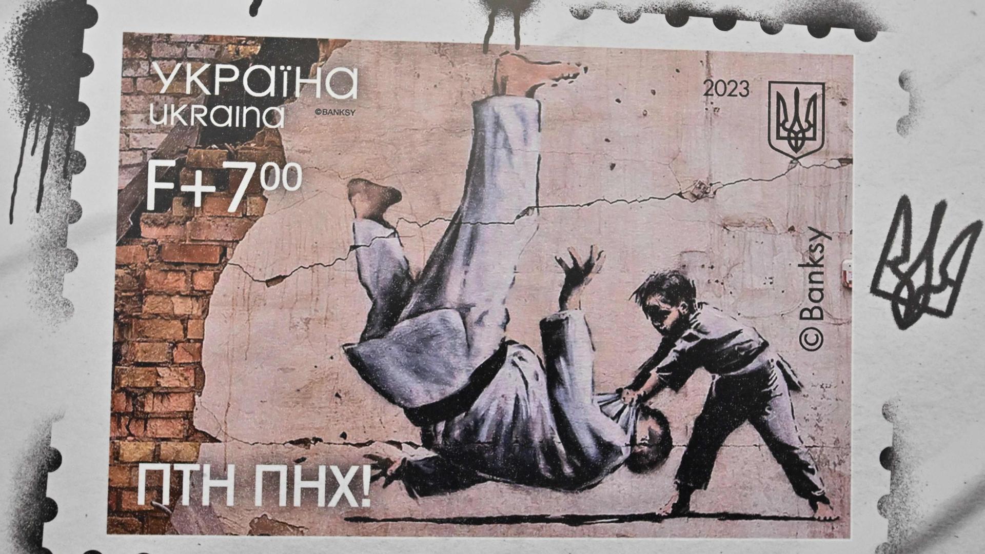Die Ukraine gibt zum Jahrestag des russischen Angriffkriegs eine Briefmarke mit einem Kunstwerk des Künstlers Banksy heraus. Er hatte das Graffito in der Ukraine hinterlassen. Es zeigt ein kleines Kind wirft darin einen viel größeren Judoka zu Boden - der vermutlich Putin darstellen soll.