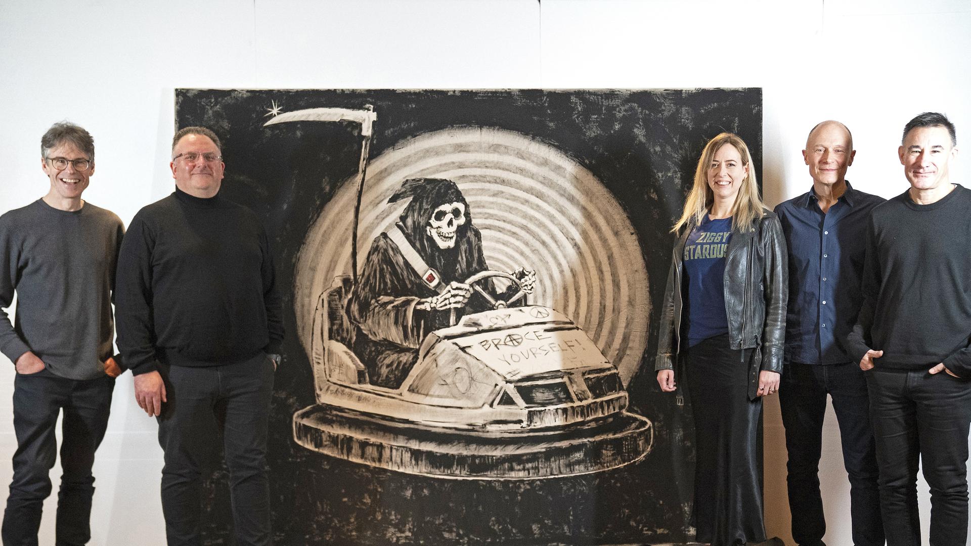 ie Mitglieder der Band Brace Yourself! stehen neben einem Banksy Werk, das einen Sensenmann in einem Autoscooter zeigt und nach der Band benannt ist, aufgenommen am 23.03.2009 