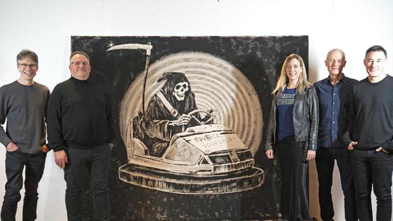 ie Mitglieder der Band Brace Yourself! stehen neben einem Banksy Werk, das einen Sensenmann in einem Autoscooter zeigt und nach der Band benannt ist, aufgenommen am 23.03.2009 