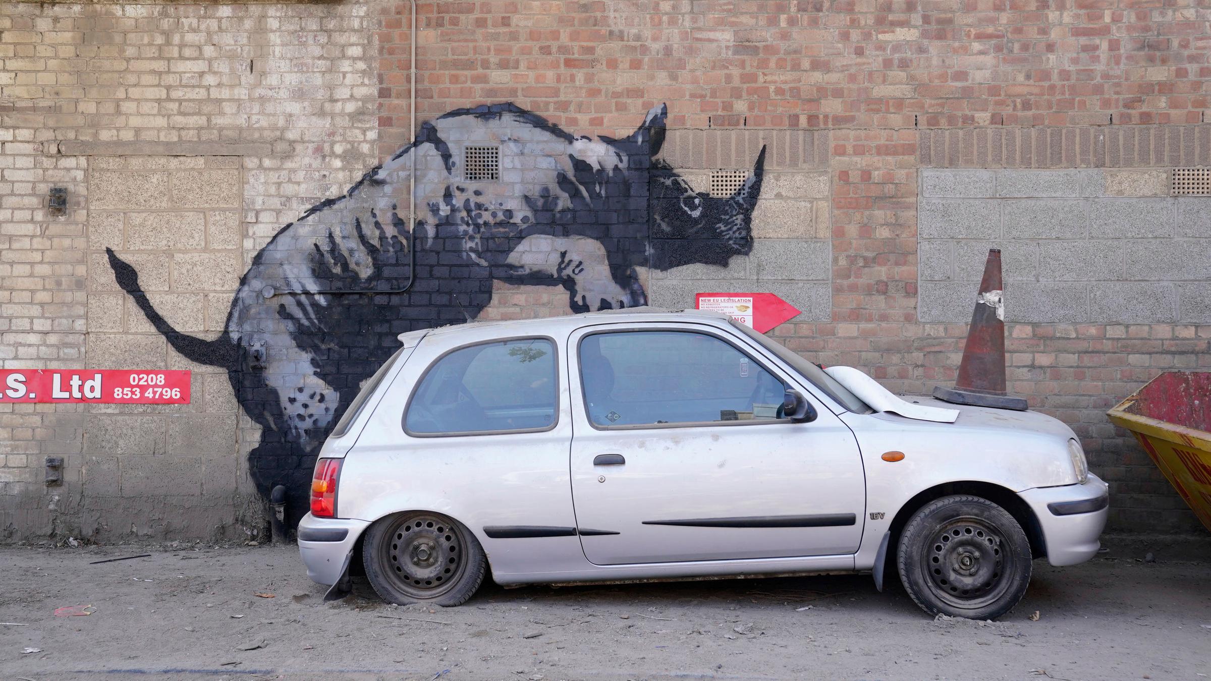 Ein neues Banksy-Kunstwerk. Ein Nashorn, dass auf ein Auto "klettert"