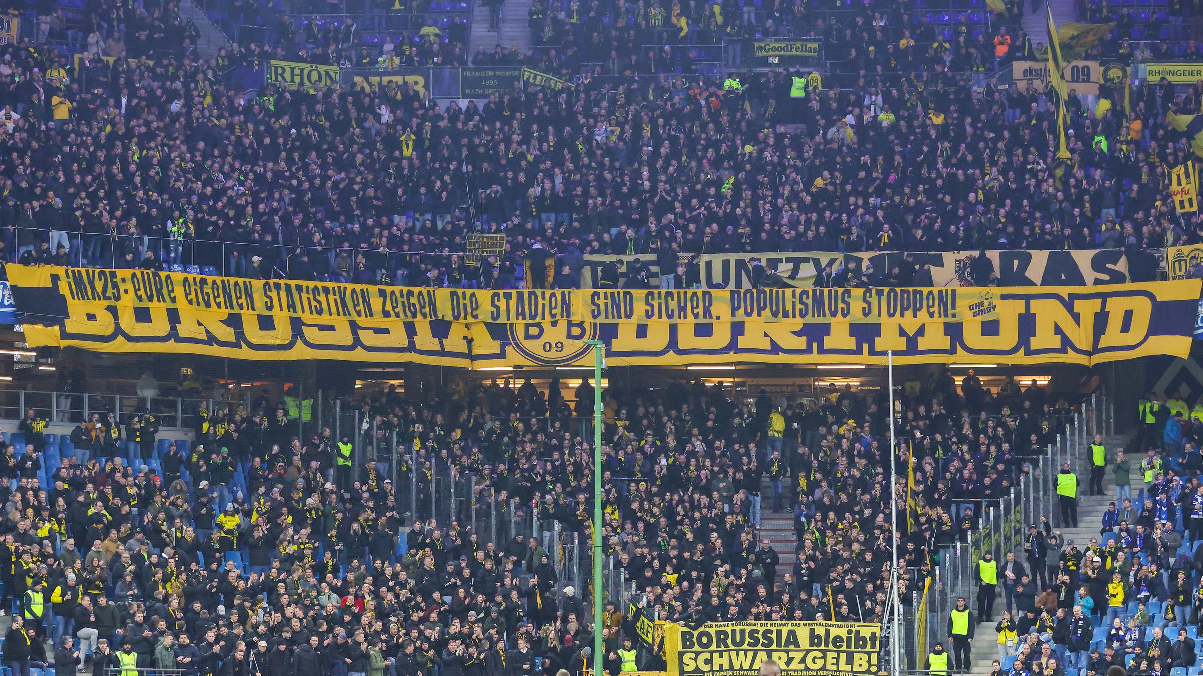 Fans von Borussia Dortmund halten einen großen Banner in der Fankurve nach oben am 08.11.2025.