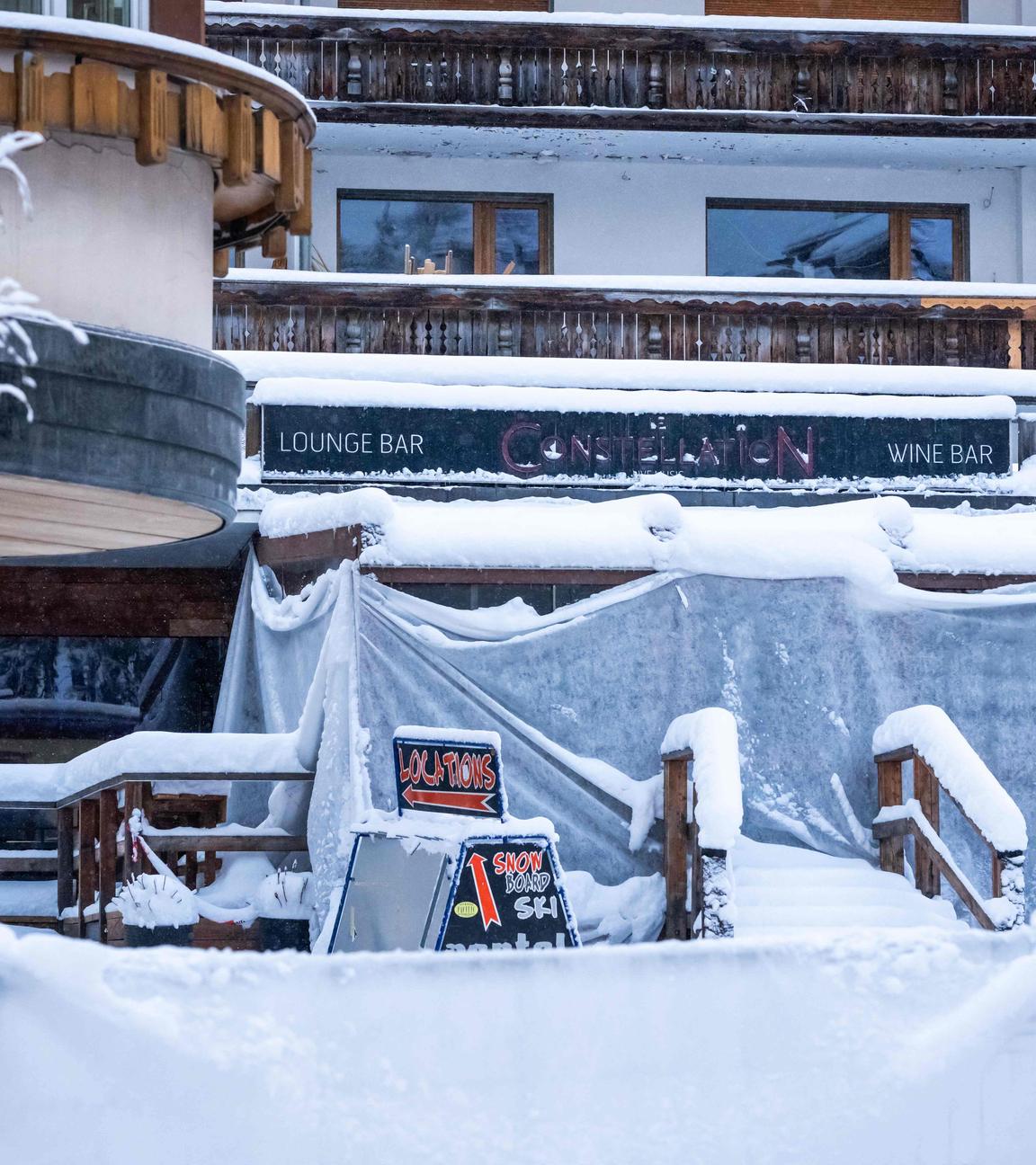 Dieses Foto zeigt die Fassade der Bar "Le Constellation“, in der das Feuer ausbrach, aufgenommen unter dem Schnee während eines nationalen Trauertages in Crans-Montana