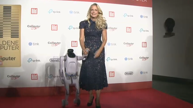 Auf dem Bild zu sehen ist: in einer Halbtotalen Barbara Schöneberger und ein Roboter