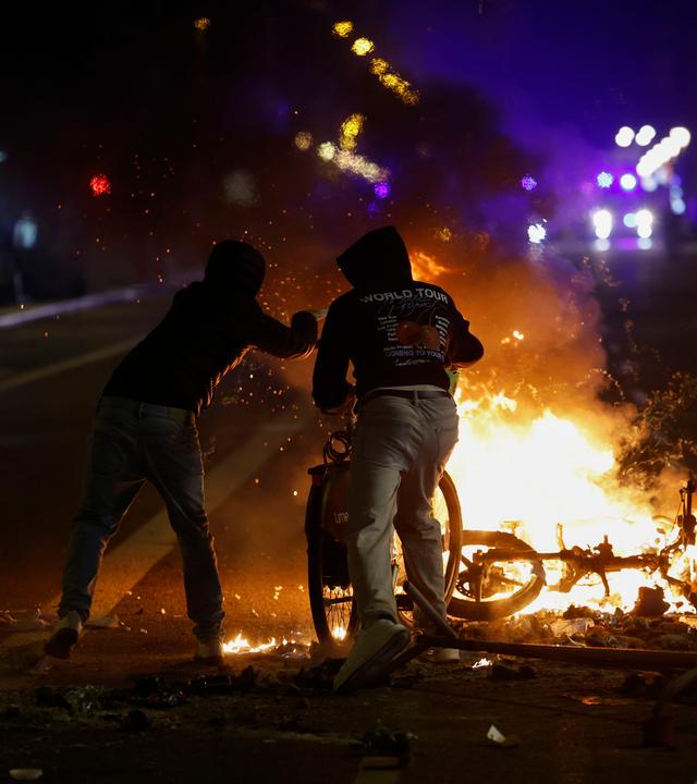 Bei Zusammenstößen zwischen Demonstranten und der Polizei in Barcelona zünden Menschen Gegenstände auf einer Straßenbarrikade an