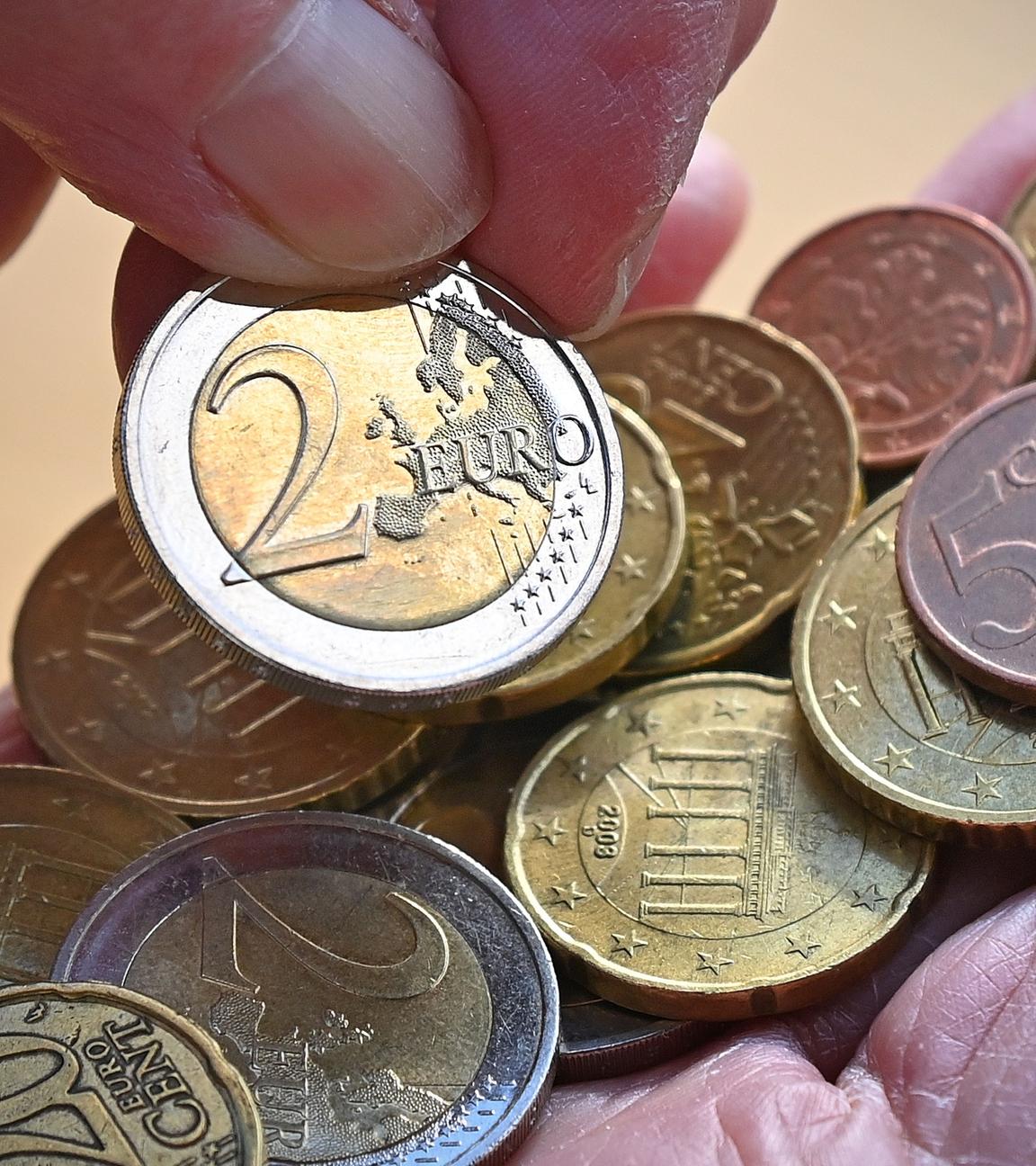 Diverse Euro-Münzen werden in der Hand gezählt.