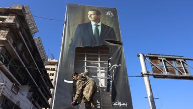 Kämpfer der Opposition zerreißen ein riesiges Porträt des syrischen Präsidenten Baschar al-Assad in Aleppo (Syrien)