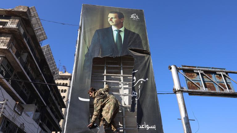 Kämpfer der Opposition zerreißen ein riesiges Porträt des syrischen Präsidenten Baschar al-Assad in Aleppo (Syrien)