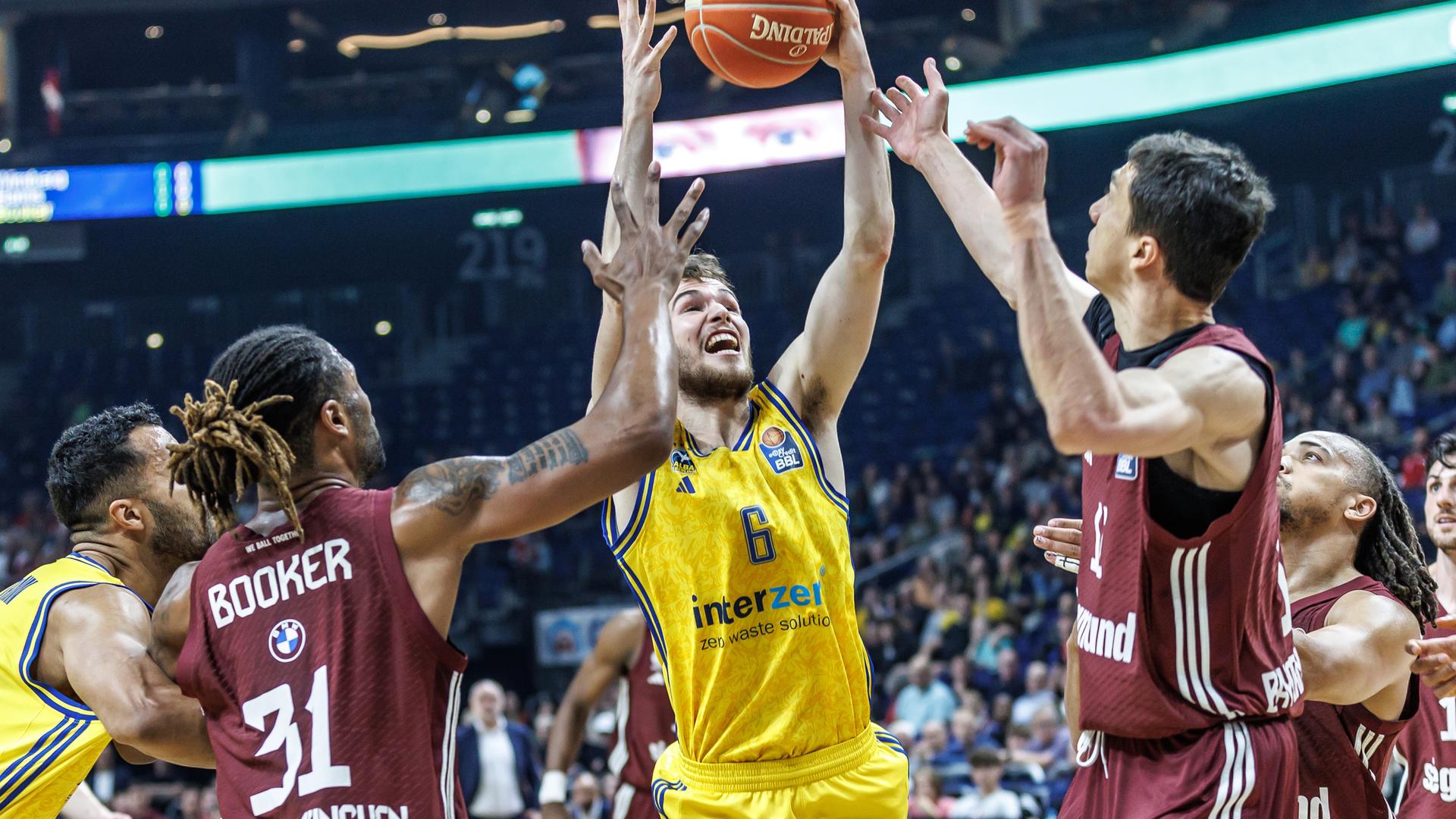 Berlin, Basketball, Bundesliga, Alba Berlin - FC Bayern München: Berlins Malte Delow (M) gegen Devin Booker (l) und Vladimir Lucic von FC Bayern München.