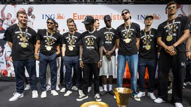 Deutschlands Team steht vor der WM- und der EM-Trophäe, (v.l.) Assistentstrainer Alan Ibrahimagic, Maodo Lo, Andreas Obst, Dennis Schröder, Johannes Voigtmann (M/hinten), Isaac Bonga, Franz Wagner, Justus Hollatz und Tristan Da Silva. 