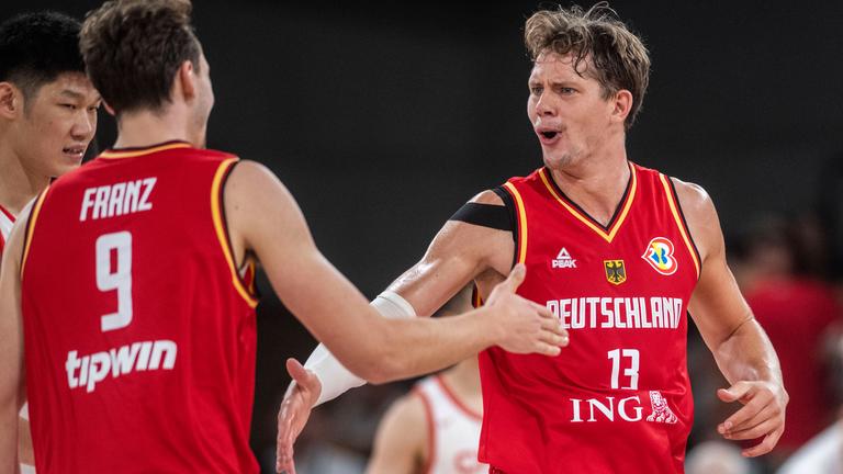 Die deutschen Basketballer Franz Wagner und Moritz Wagner freuen sich und klatschen sich ab.