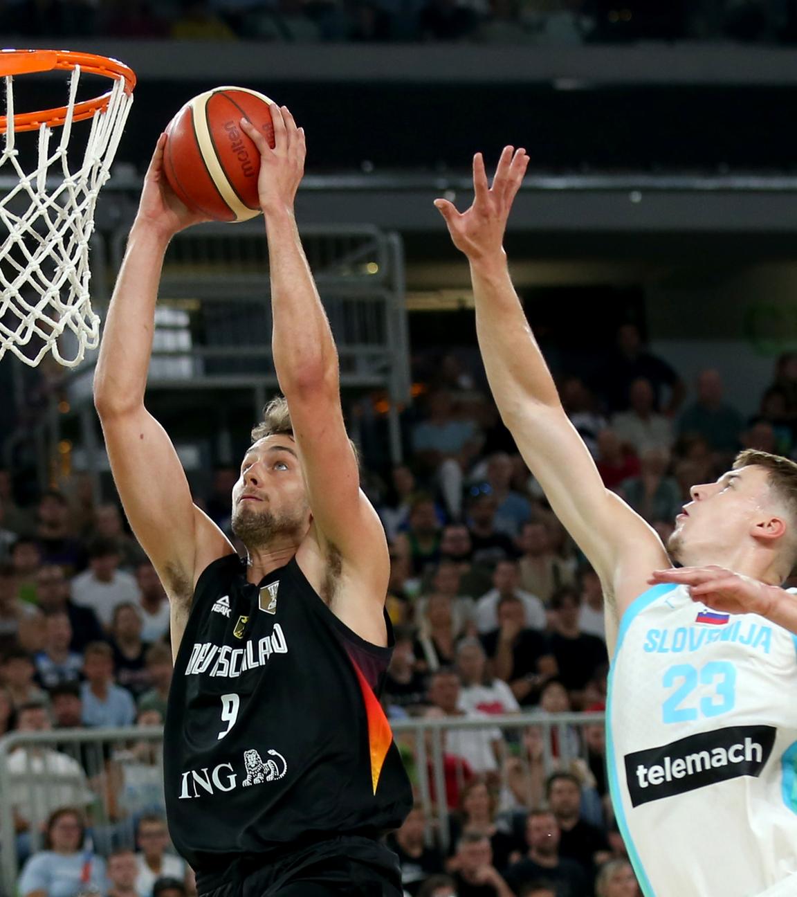 Basketballer Franz Wagner (l, Deutschland) zieht gegen Luka Scuka (Slowenien) zum Korb am 08.08.2025 Ljubljana, Slowenien.
