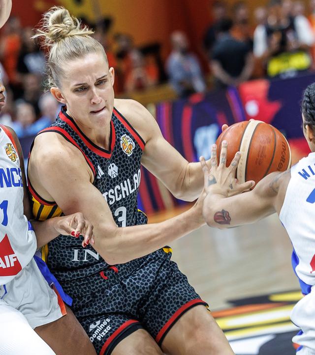 Valeriane Ayayi (l, Frankreich) und Gabby Williams (r, Frankreich) kämpfen gegen Leonie Fiebich (M, Deutschland) um den Ball.