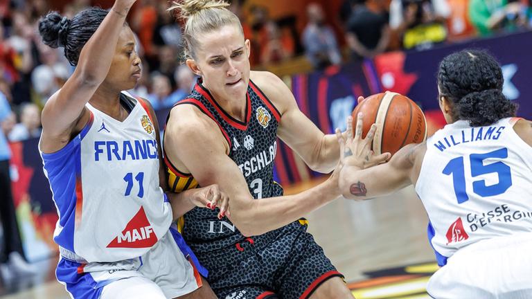 Valeriane Ayayi (l, Frankreich) und Gabby Williams (r, Frankreich) kämpfen gegen Leonie Fiebich (M, Deutschland) um den Ball.