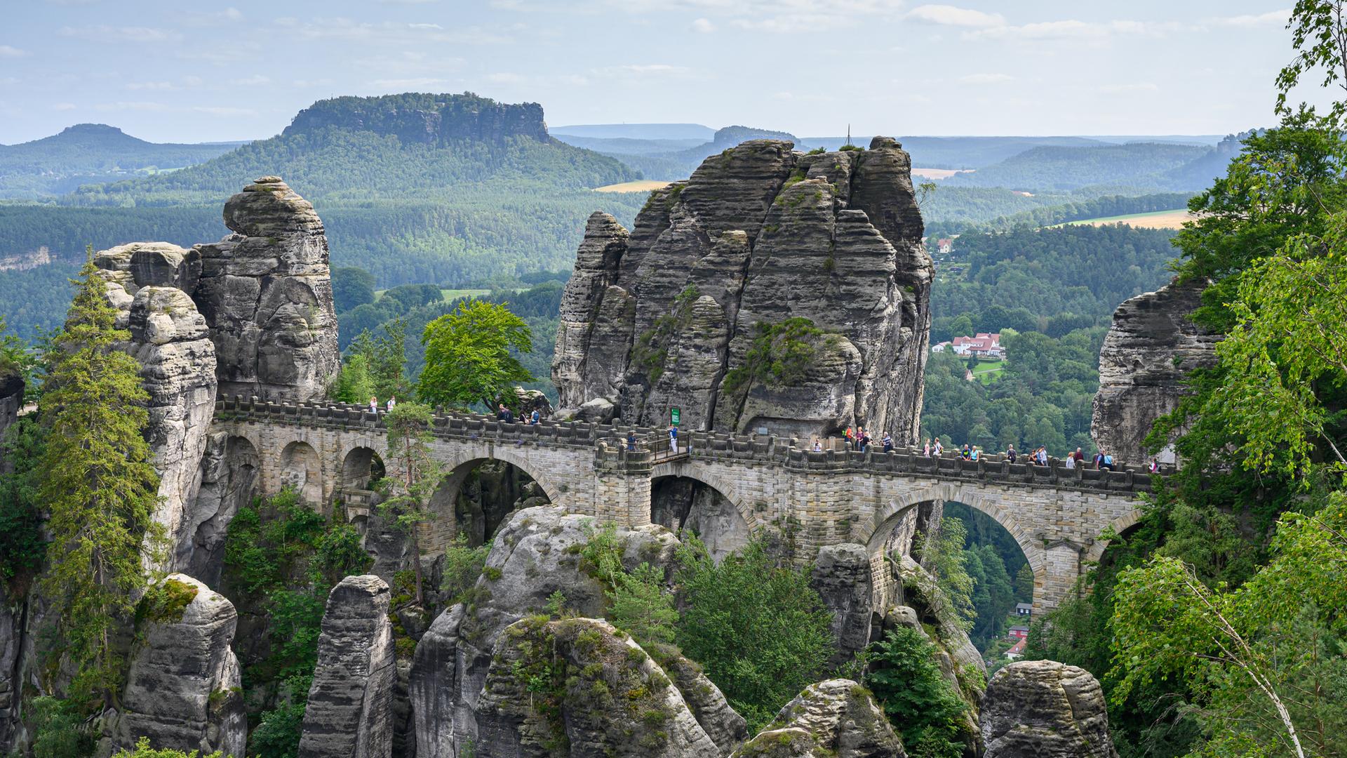 Touristen laufen über die Basteibrücke.