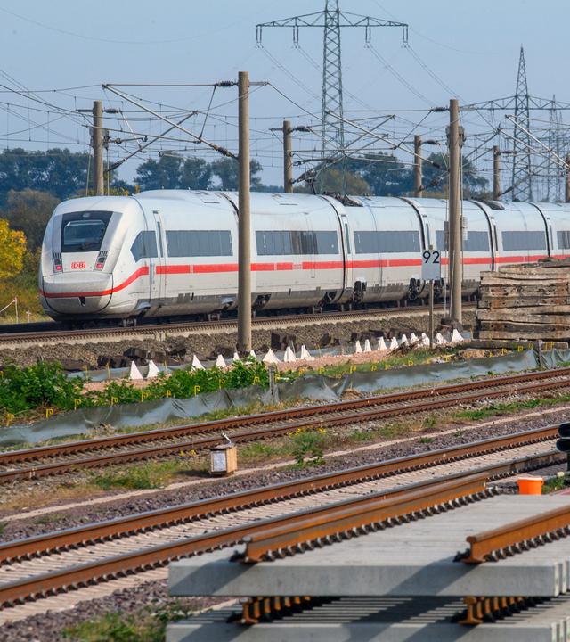 Ein ICE rollt nahe des Bahnhofs Schönhausen an Gleisbauteilen vorbei.
