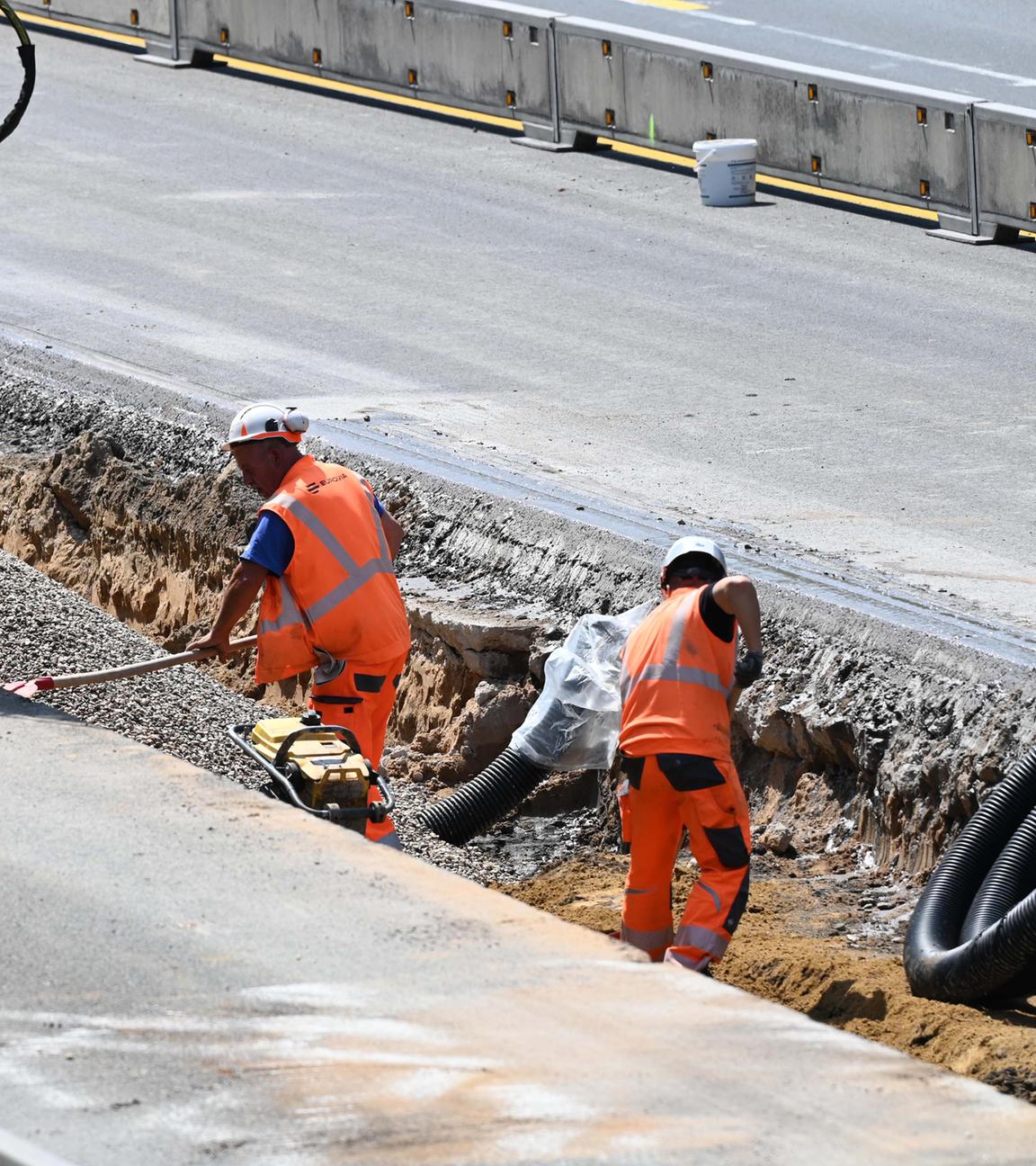 Symbolbild: Bauarbeiter und Baumaschinen bei der Arbeit