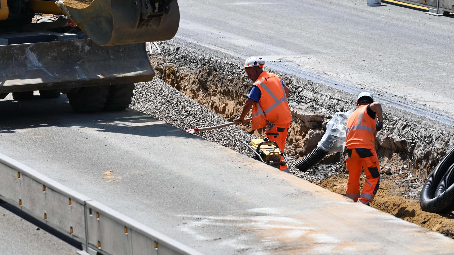 Symbolbild: Bauarbeiter und Baumaschinen bei der Arbeit