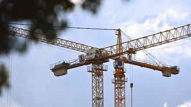 Zwei Baukräne der Firma Liebherr auf einer Baustelle.
