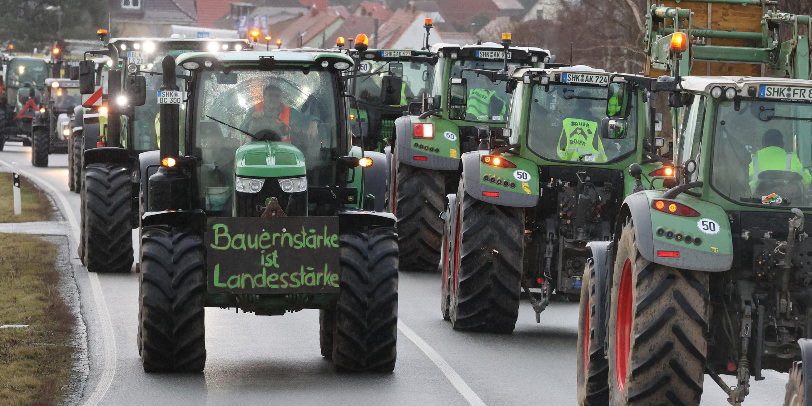 Landwirte fahren mit ihren Traktoren über die Bundesstraße 7.