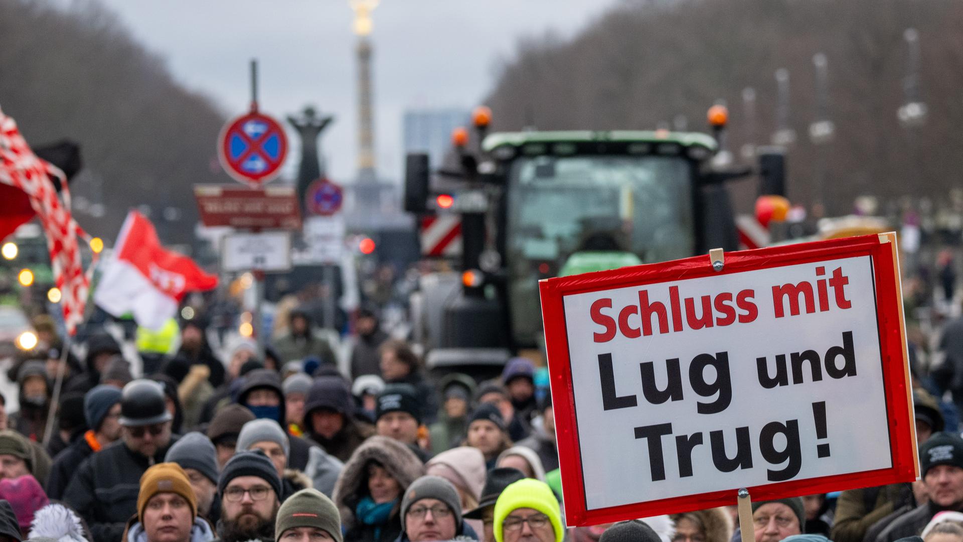 Teilnehmer der durch die Interessenvertretung Freie Bauern angemeldeten Kundgebung stehen mit Schildern und Flaggen auf der Straße des 17. Juni vor dem Brandenburger Tor