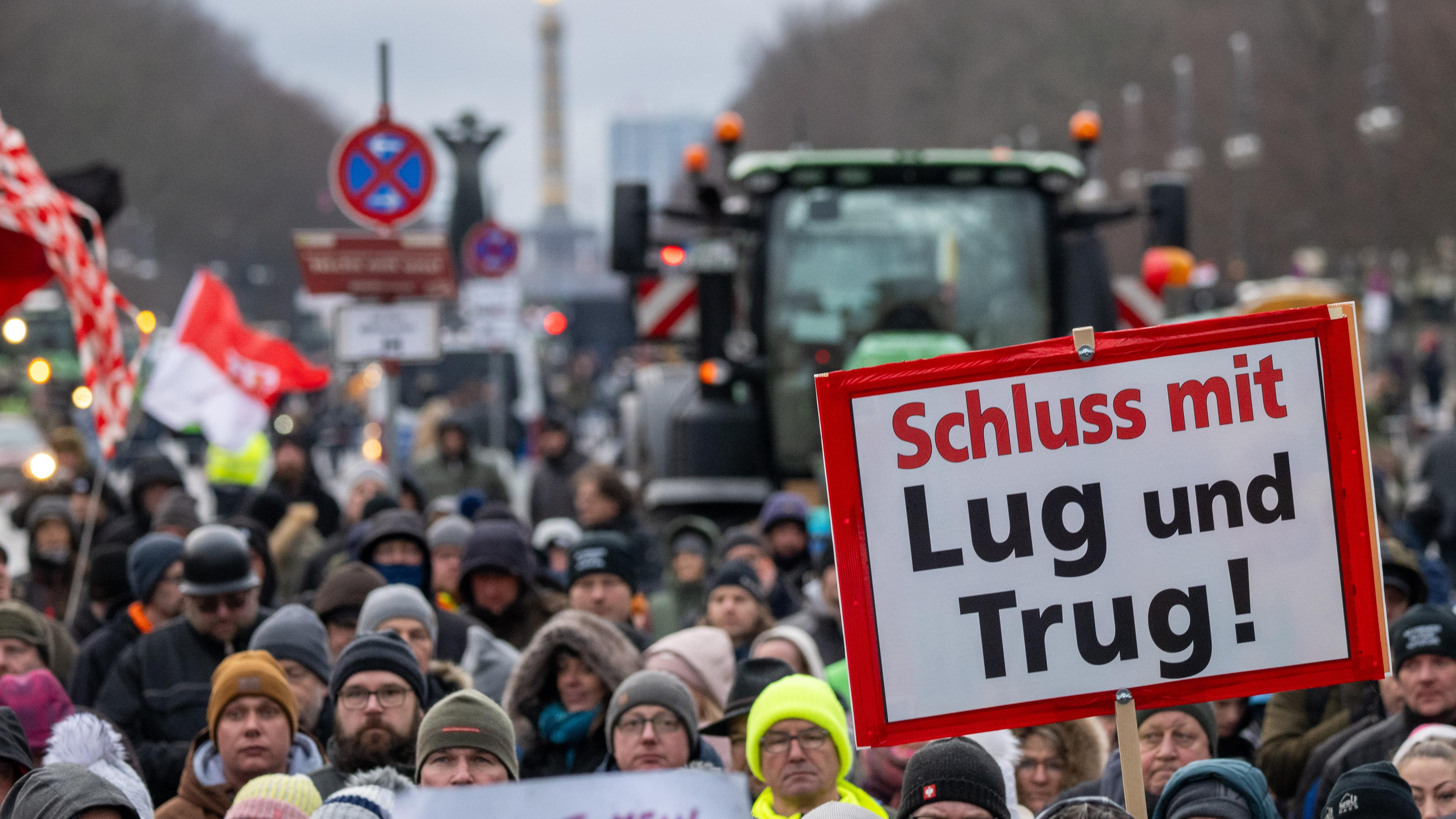 Teilnehmer der durch die Interessenvertretung Freie Bauern angemeldeten Kundgebung stehen mit Schildern und Flaggen auf der Straße des 17. Juni vor dem Brandenburger Tor