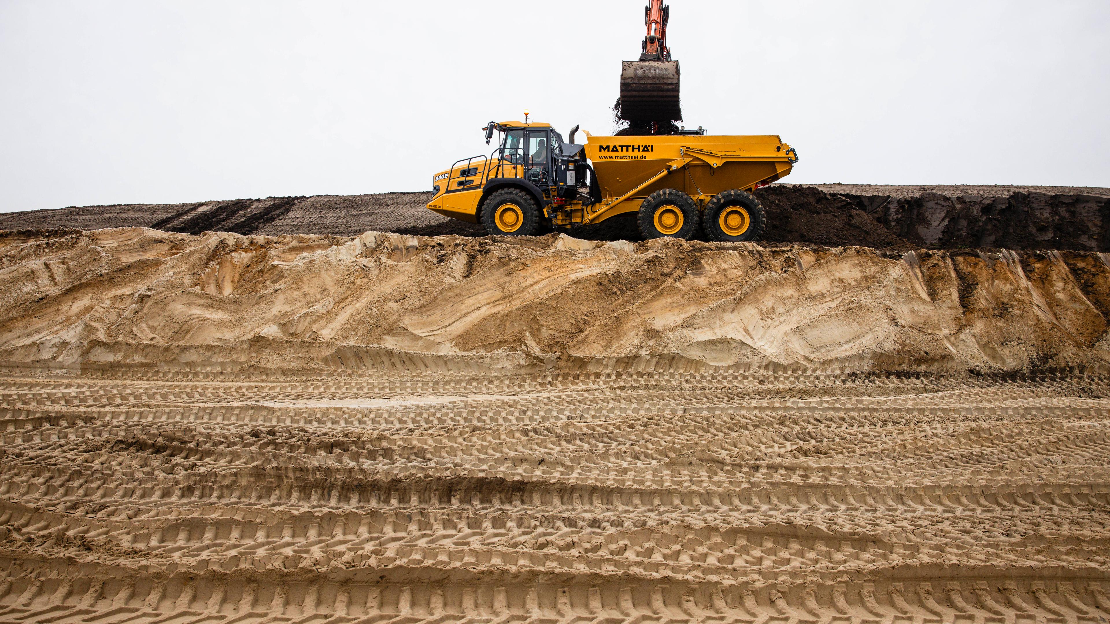 Schleswig-Holstein, Heide: Ein LKW transportiert Sand auf einer Baustelle im Kreis Dithmarschen ab.