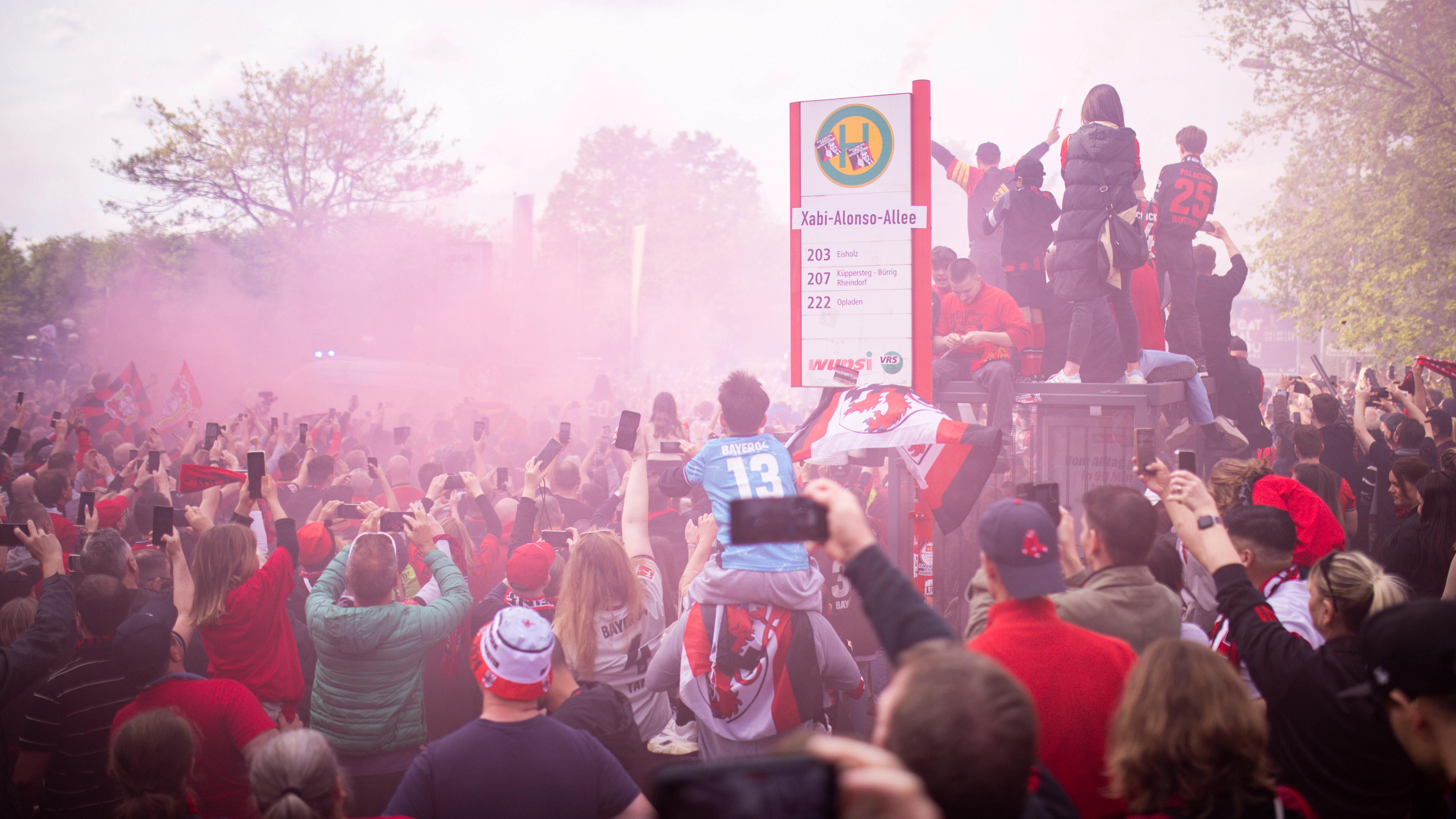 Fans empfangen den Mannschaftsbus an der Xabi-Alonso-Allee.