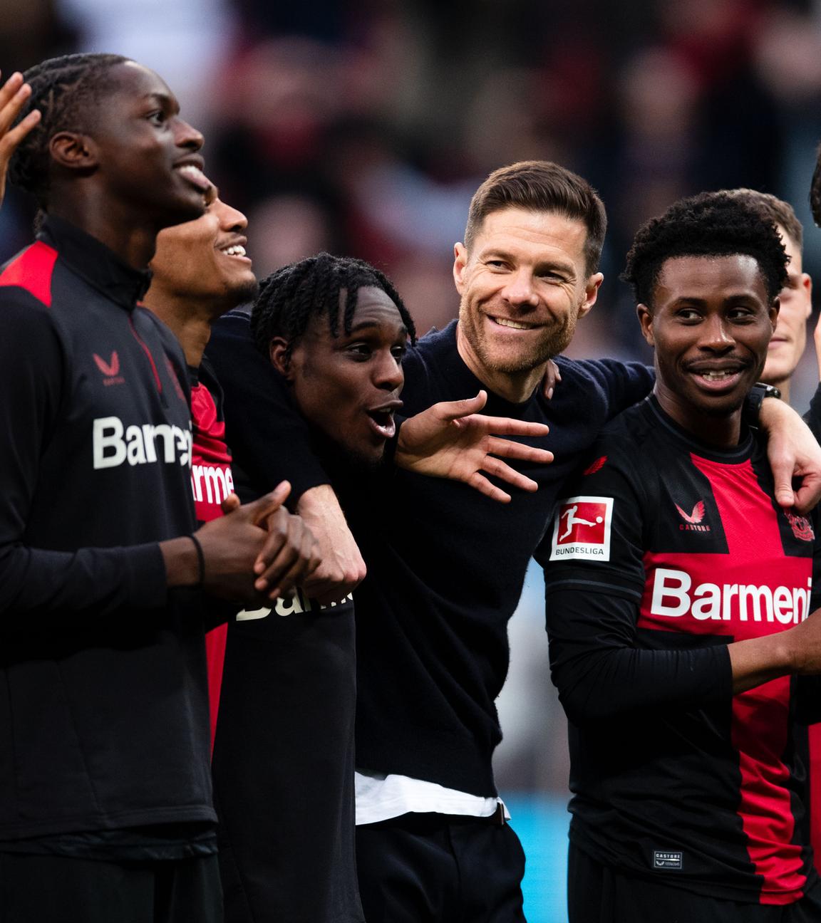 Trainer Xabi Alonso feiert mit seinen Spielern von Bayer Leverkusen