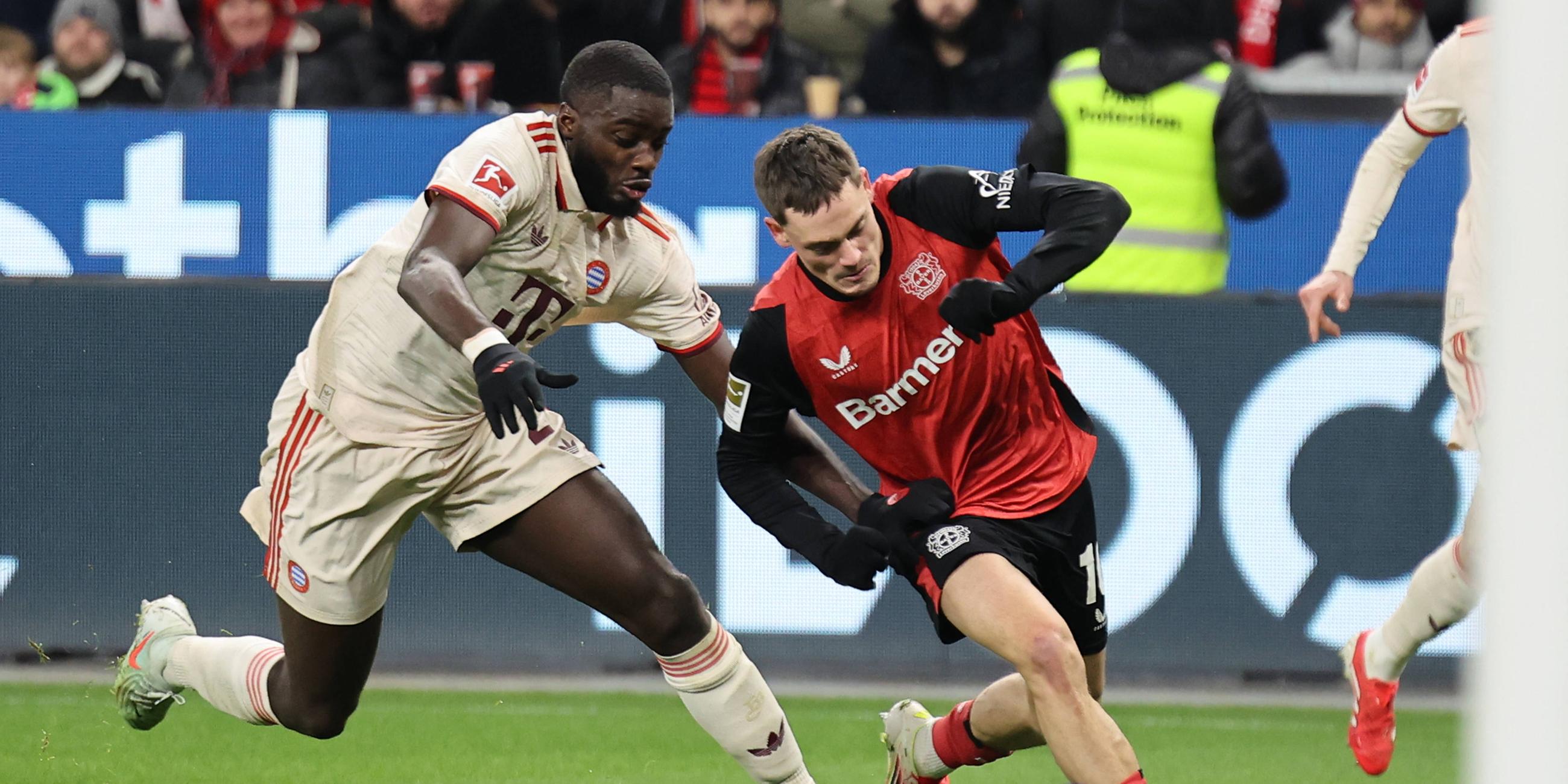 im Bild: Florian Wirtz (Leverkusen) im Zweikampf gegen Dayot Upamecano (Bayern Muenchen).