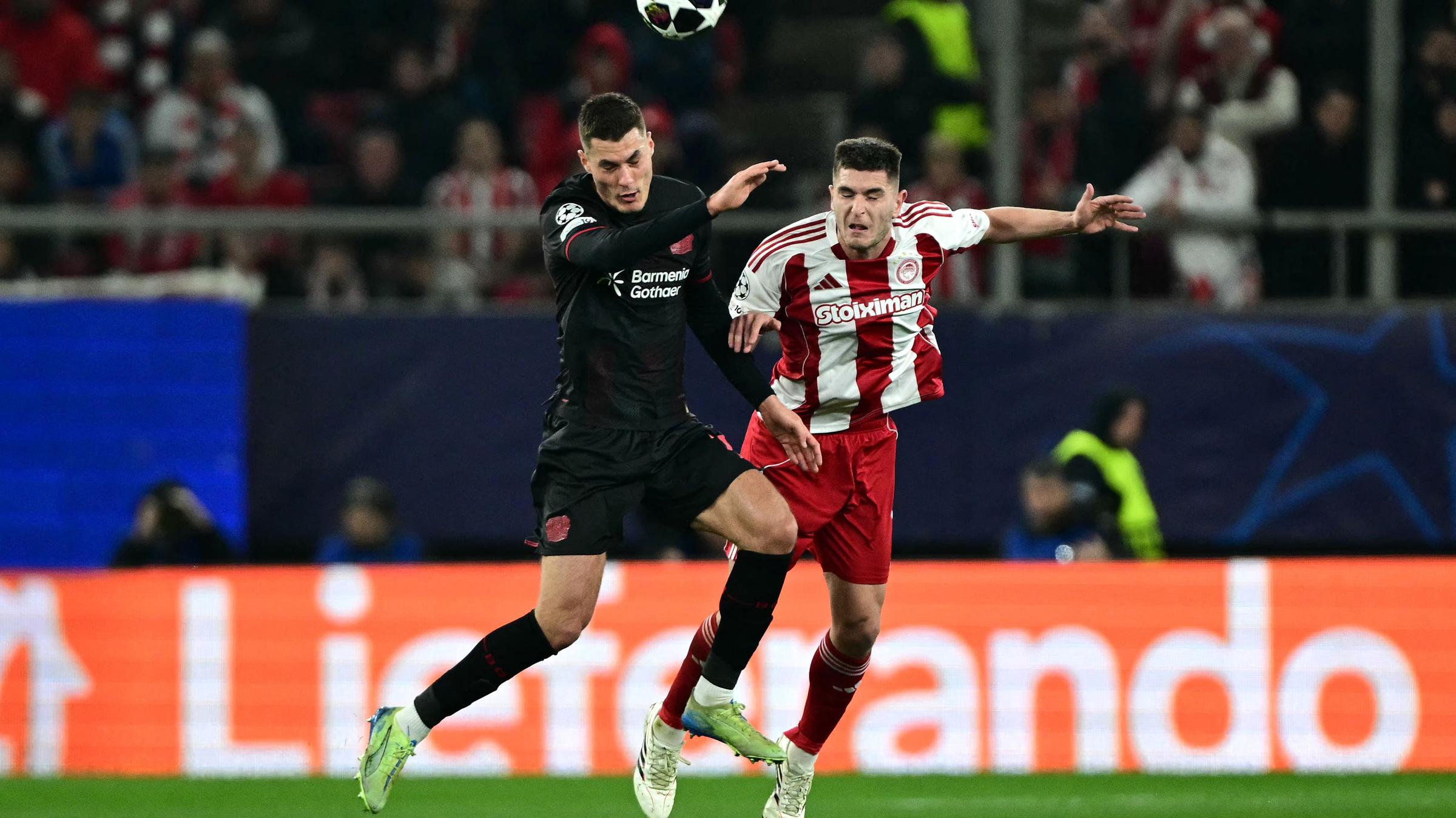 Patrik Schick (Bayer Leverkusen) und Lorenzo Pirola (Olympiakos) kämpfen. 