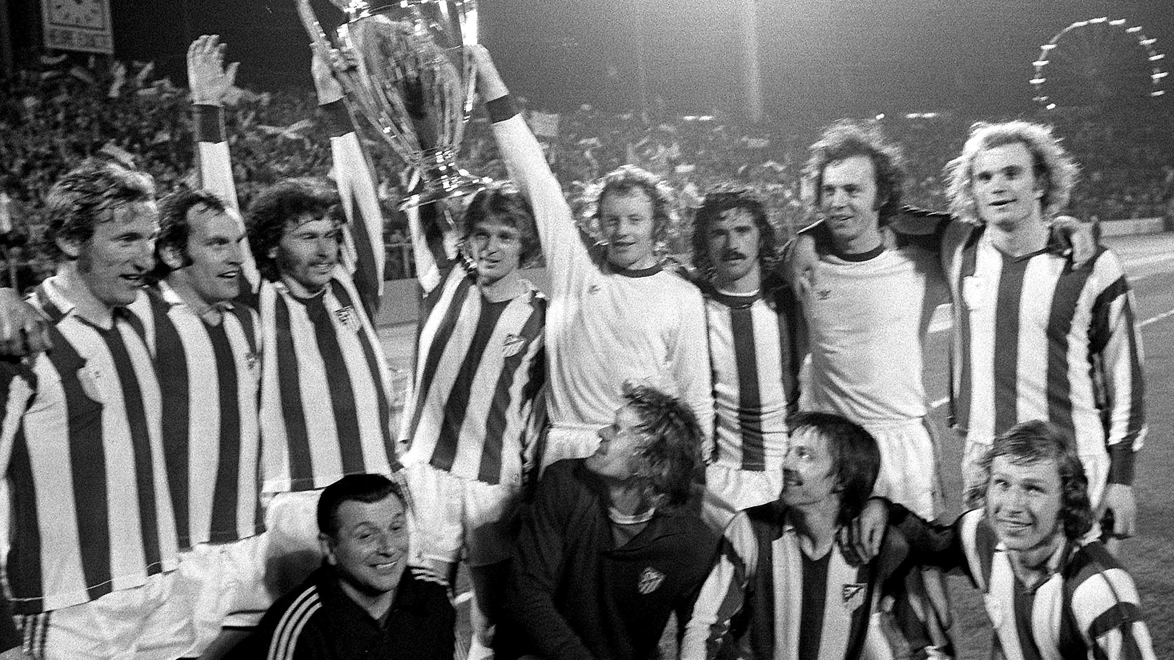 Archiv: Die Bayernspieler halten jubelnd den Pokal. 