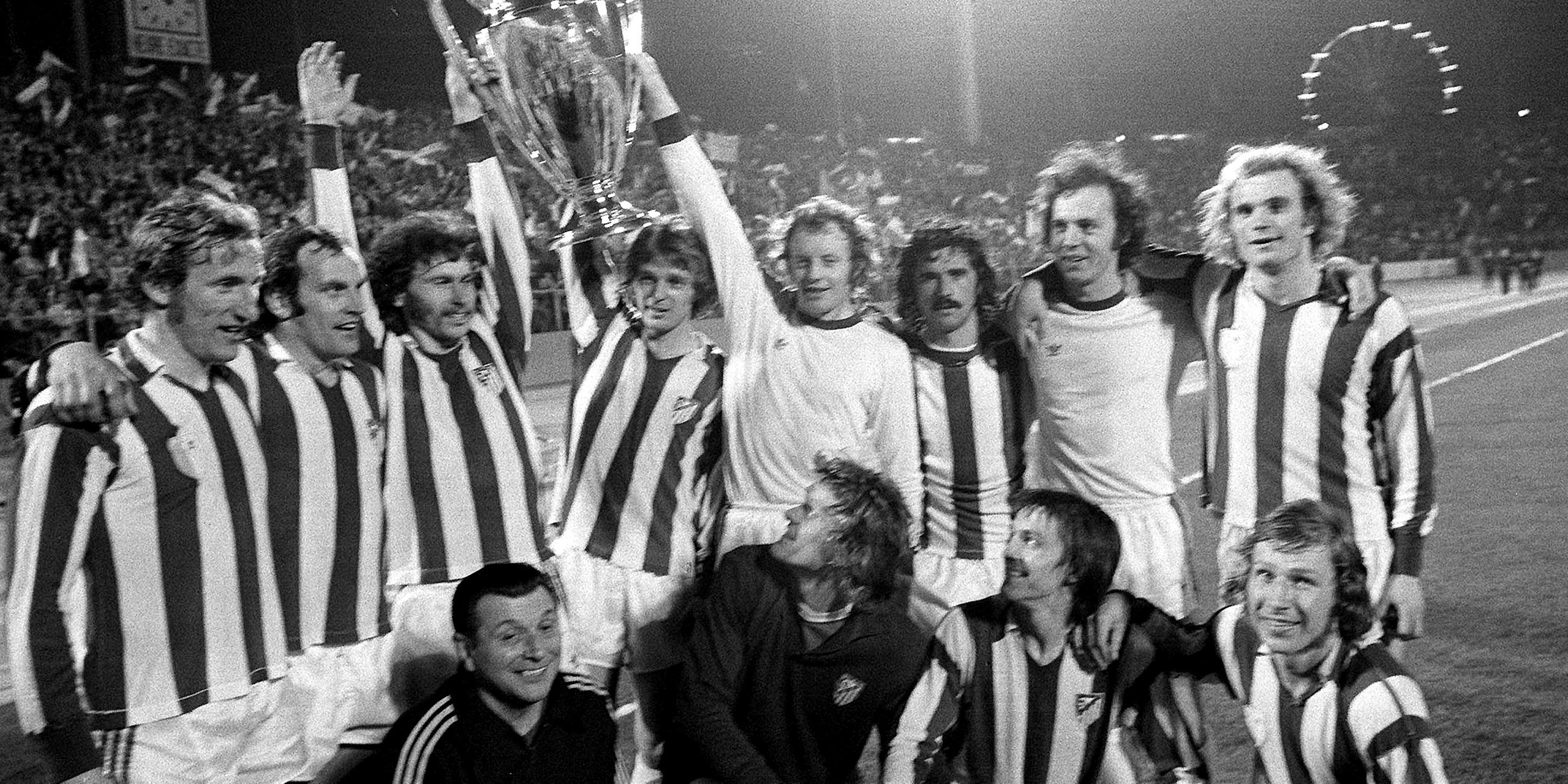 Archiv: Die Bayernspieler halten jubelnd den Pokal. 