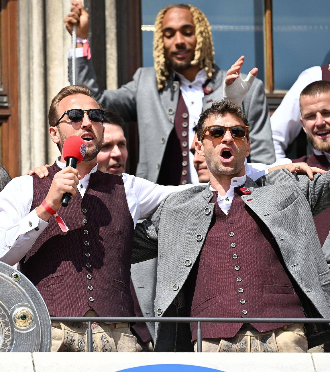 Harry  kane und Thomas Müller feiern auf dem Rathausbalkon mit Meisterschale.