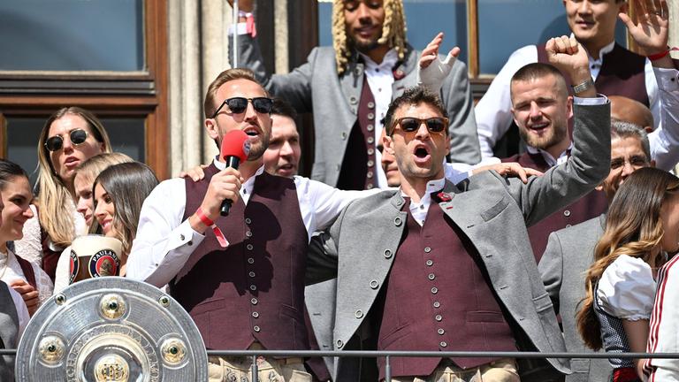 Harry  kane und Thomas Müller feiern auf dem Rathausbalkon mit Meisterschale.