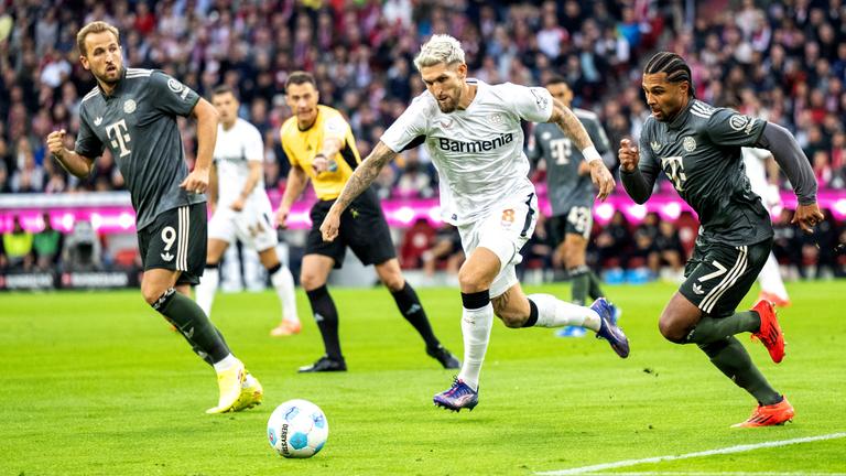 Harry Kane (München), Robert Andrich (Leverkusen) und Serge Gnabry (München) kämpfen um den Ball am 28.09.24.