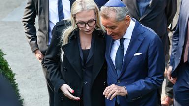 Katharina Wagner (l), künstlerische Leiterin der Bayreuther Festspiele, und Michel Friedman halten sich nach dem Gedenken an der Außen-Ausstellung «Verstummte Stimmen» vor den Stelen die Hand.