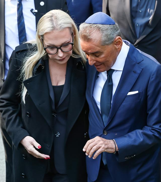 Katharina Wagner (l), künstlerische Leiterin der Bayreuther Festspiele, und Michel Friedman halten sich nach dem Gedenken an der Außen-Ausstellung «Verstummte Stimmen» vor den Stelen die Hand.