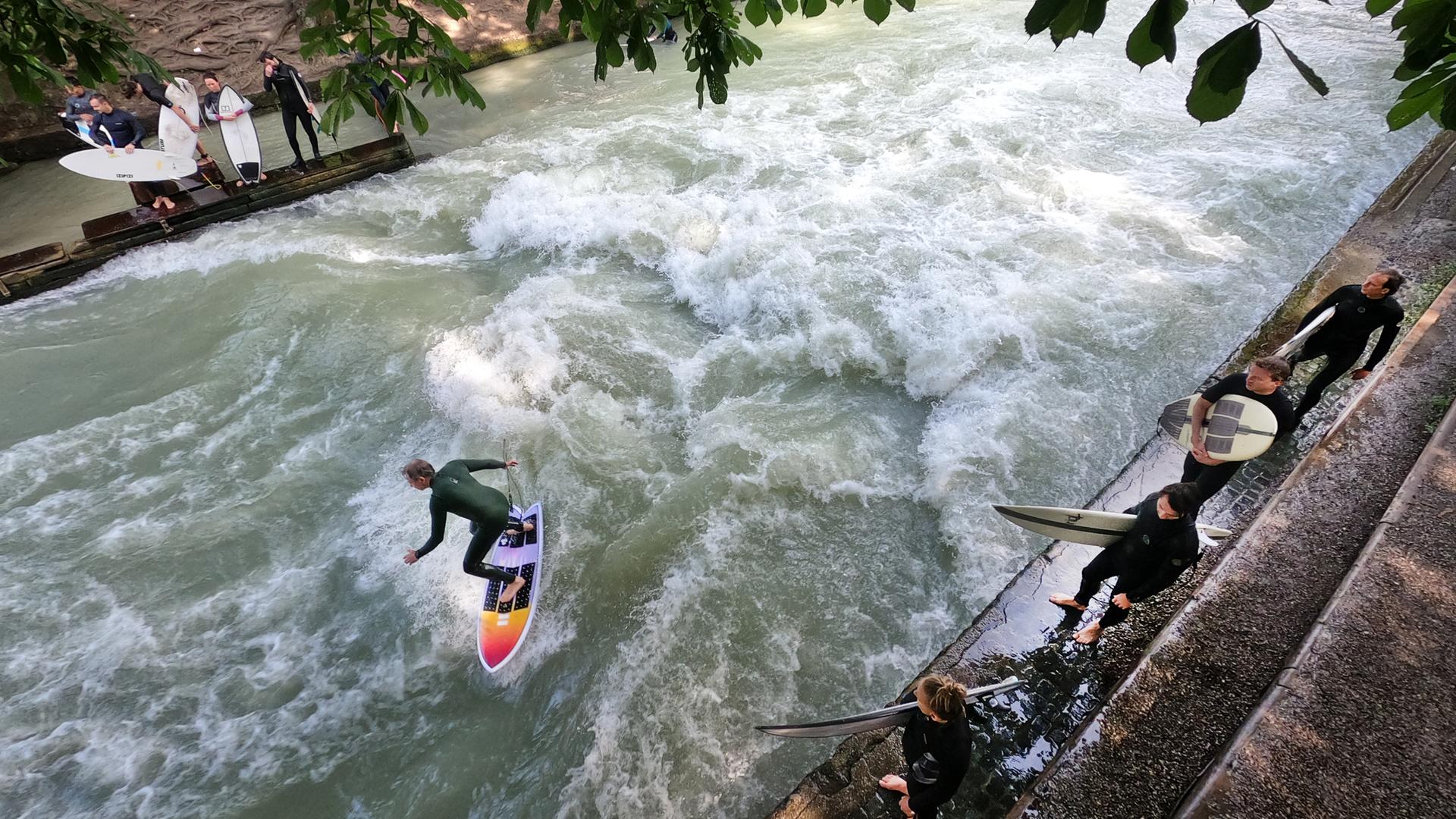 Ein Surfer "reitet" auf der Eisbachwelle im Englischen Garten. Die künstliche Welle gilt das ganzen Jahr und bei jedem Wetter als ein beliebter Hotspot für Surfer und Zuschauer.