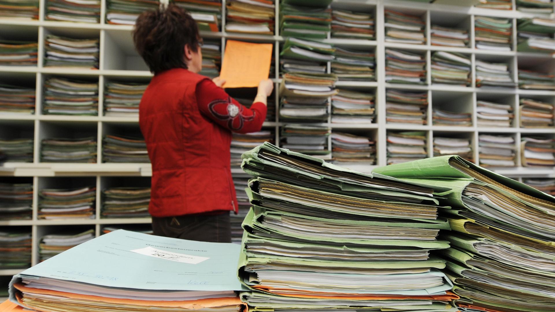 Eine Beamte holt Akten aus einem Regal im Finanzamt Straubing, Niederbayern (Archivbild).
