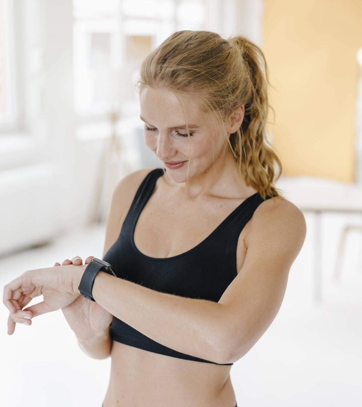Frau beim Sport schaut auf die Uhr
