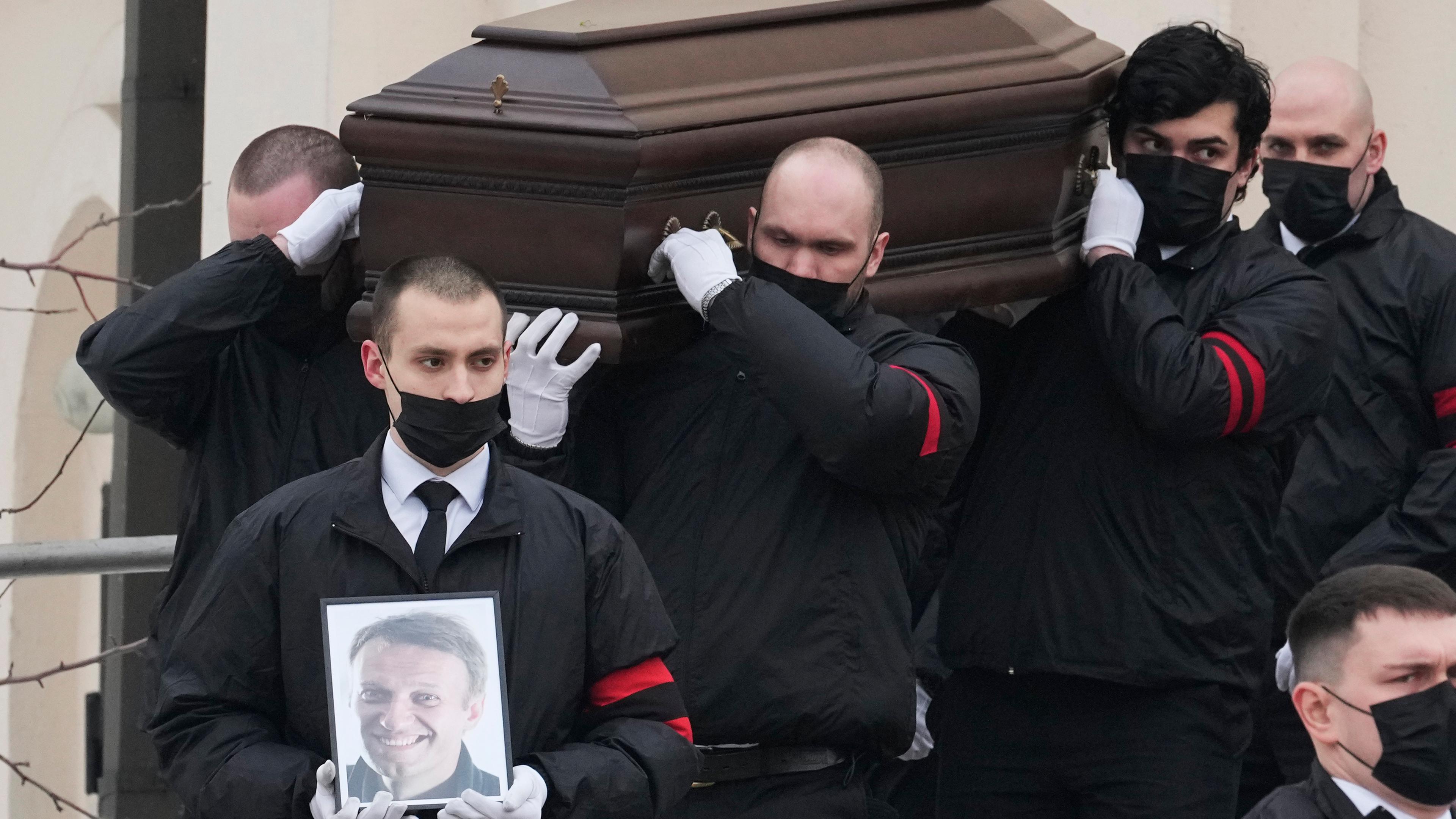 Russland, Moskau: Männer tragen den Sarg und ein Porträt des russischen Oppositionsführers Alexej Nawalny aus der Kirche zu Ehren der Gottesmutterikone "Lindere meine Trauer" im südöstlichen Bezirk Marjino.